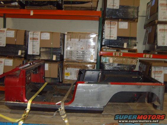 Jeep CJ body on a pallet, strapped down in a warehouse