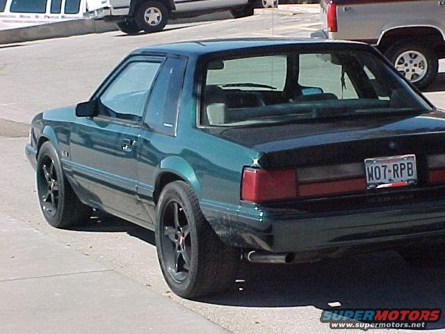 Green 1992 Ford Mustang coupe, rear 3/4 view, black aftermarket wheels, tinted windows, license plate W07-RPB