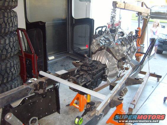 Engine and transmission assembly on a frame with tires stacked nearby