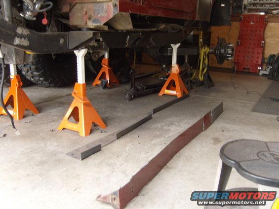 Jeep chassis on orange jack stands, with large tires visible