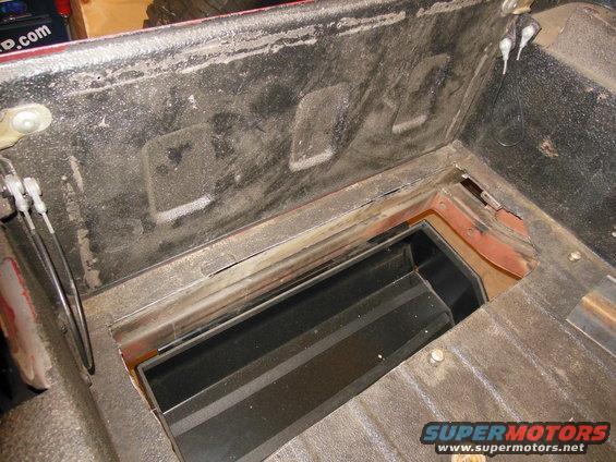 Under-seat storage compartment in a vehicle bed