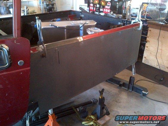 Red Jeep CJ body panel, dark gray, held by clamps, on jack stands
