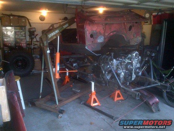 1985 Jeep CJ7 body and frame on jack stands with engine removed, in a garage