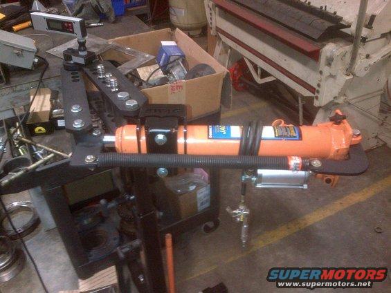 Tube bender with orange hydraulic ram and digital readout