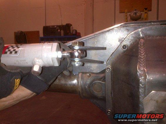 Shock absorber with checkered sticker attached to a metal bracket on a differential housing