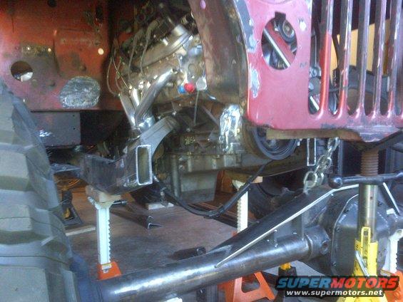 Jeep CJ frame on jack stands with engine and suspension components visible during work