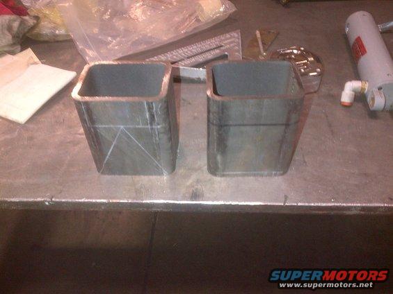 Two square metal tubes with scribe lines on a workbench