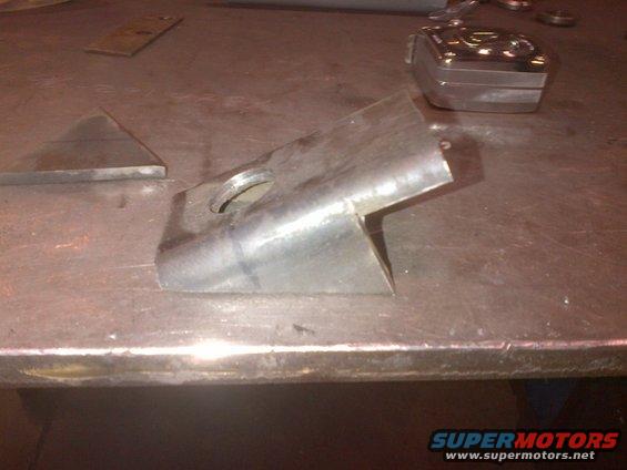 metal bracket with hole and angled cut, on a workbench