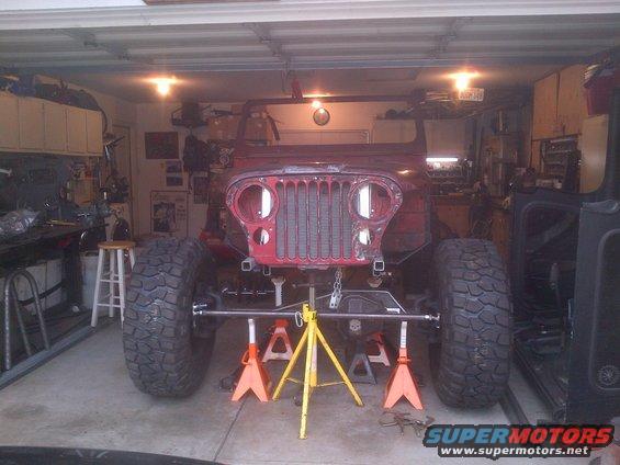 1985 Jeep CJ7 body on jack stands in a garage, front view