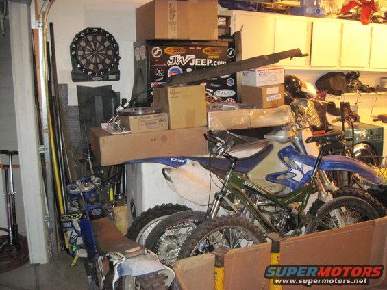 Motorcycles and boxes in a cluttered garage