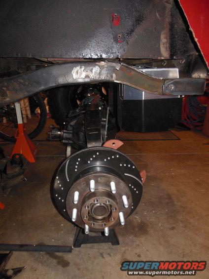 Jeep CJ frame with suspension and brake assembly on jack stands