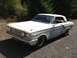 1964 Ford Fairlane - A white 1964 Ford Fairlane coupe sits on a gravel surface, showing primer patches on its bodywork.