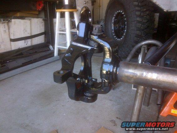 Black painted front axle assembly with large off-road tire visible