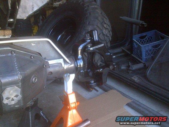 Jeep Dana 44 axle assembly with skull decal, supported by jack stands