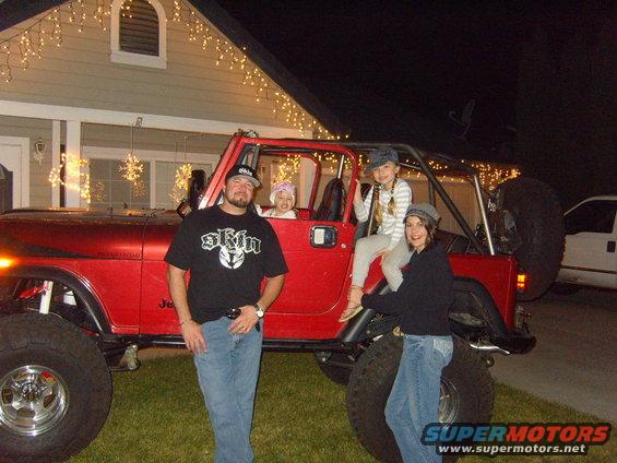 Red 1985 Jeep CJ7 with family posing in front