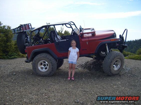 Red 1985 Jeep CJ7 with roll cage and spare tire carrier