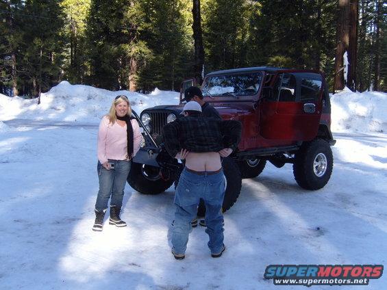 1985 Jeep CJ7 in snow with two people standing nearby