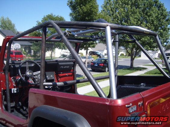 1985 Jeep CJ7 interior showing dashboard, steering wheel, and custom roll cage. "CJ Jeep" text visible on dash