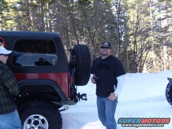 Red Jeep CJ7 with spare tire on rear, in snow
