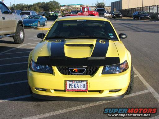 Yellow 2003 Ford Mustang with black racing stripes on the hood and trunk