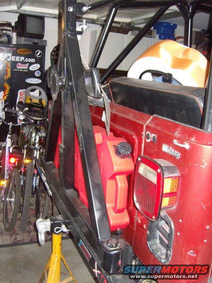 1985 Jeep CJ7 rear view with red jerry can mounted on external carrier, roll cage visible