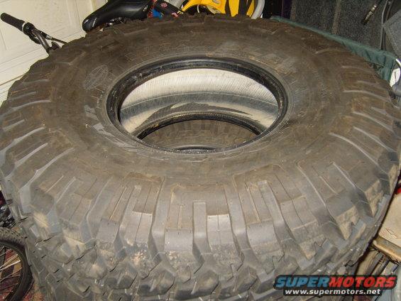 Stack of large off-road tires with aggressive tread pattern