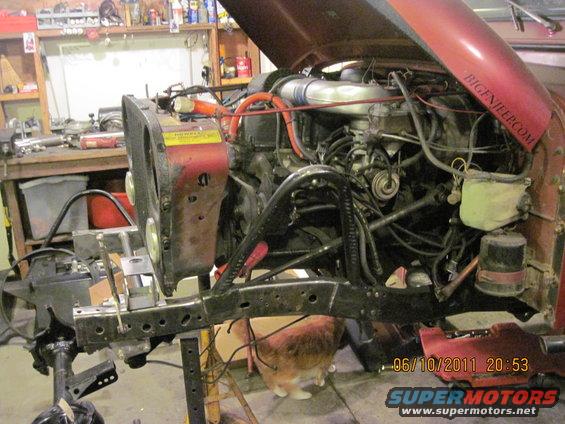 1985 Jeep CJ7 engine bay with hood open, showing engine and front chassis components during repair. BIGENJEEP.COM visible on hood