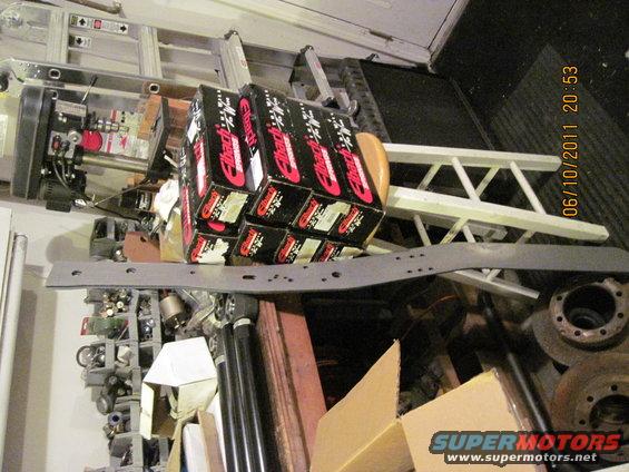 Boxes of Eibach springs stacked, with vehicle parts and ladders