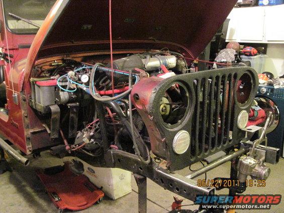 1985 Jeep CJ7 engine bay with hood open, showing engine and front grille removed