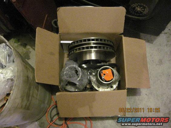 Cardboard box with brake rotors and hub assemblies, some wrapped in plastic
