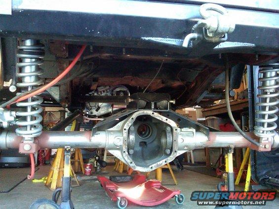 Jeep rear axle assembly with differential housing removed, supported by jack stands