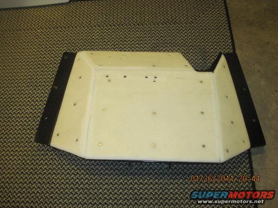White plastic part with black trim on carpet