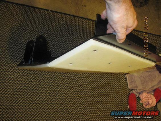 hand holding a skid plate with mounting brackets