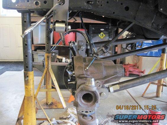 Jeep chassis and suspension parts on jack stands, with a differential visible