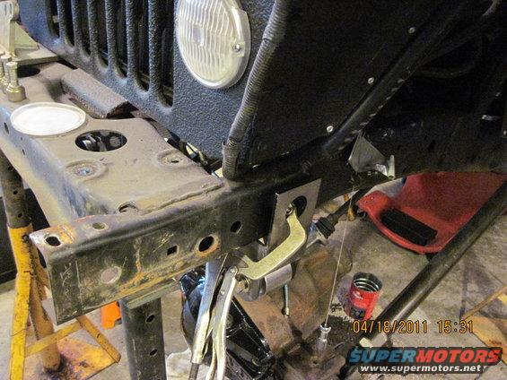 Close-up of a Jeep frame with tools and parts around it, showing ongoing work