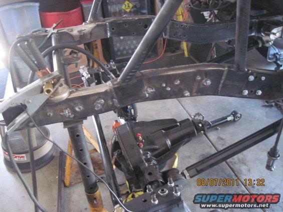 Jeep frame with differential and suspension parts, undergoing modification