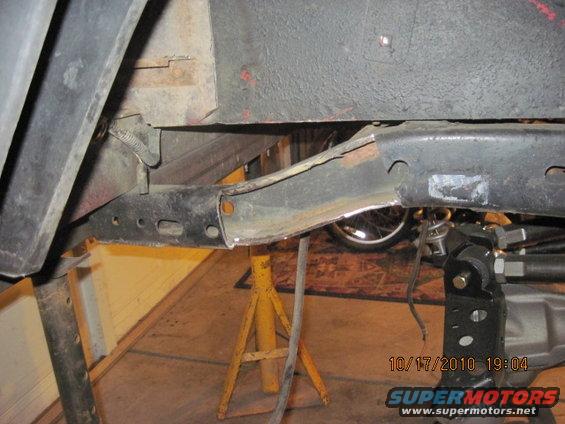 close-up of vehicle frame being modified, supported by jack stands