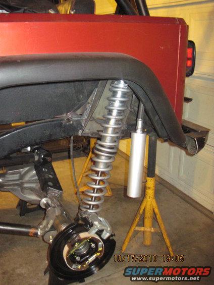Red Jeep rear suspension with coilover shock and brake assembly