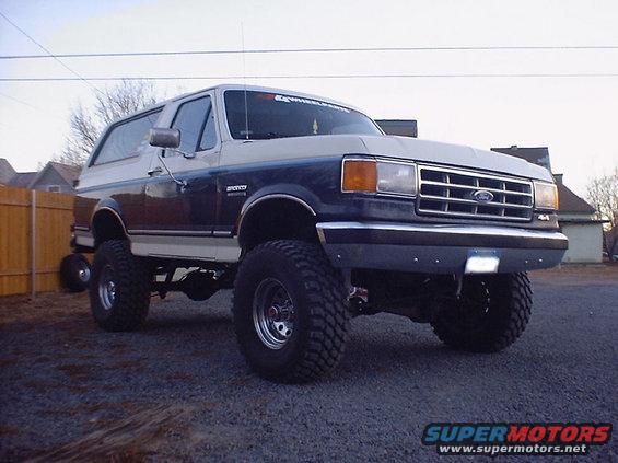 1988 Ford Bronco lifted with large off-road tires, two-tone paint