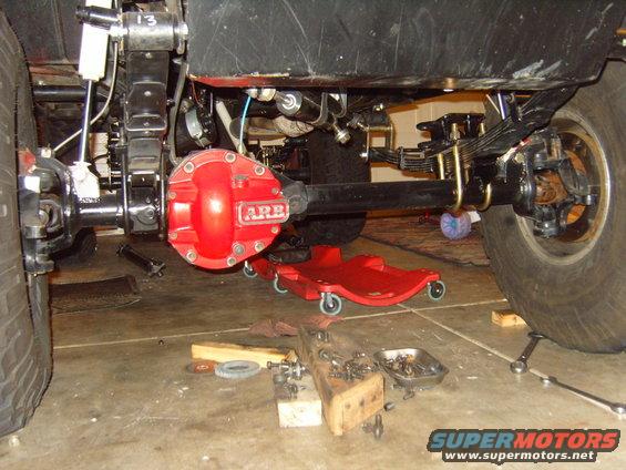 Red ARB differential cover on a black axle, with leaf springs and tires visible