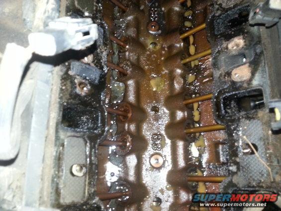 Close-up of a dirty engine block with visible pushrods and electrical connectors