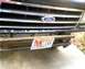 1991 Ford Bronco - Close-up of a Ford grille and bumper assembly, with a license plate attached.