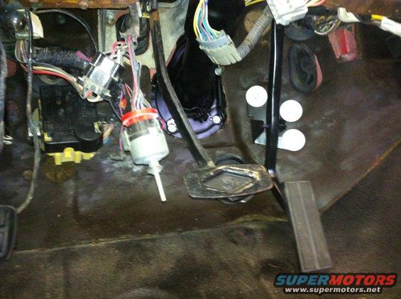 Interior footwell with brake and accelerator pedals, and exposed wiring harness