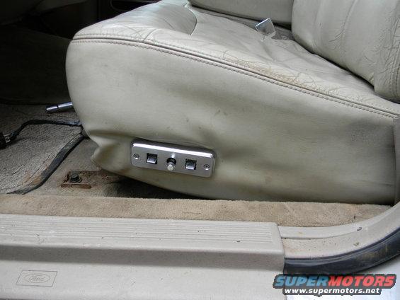 Close-up of a car's power seat controls with three buttons and two square buttons