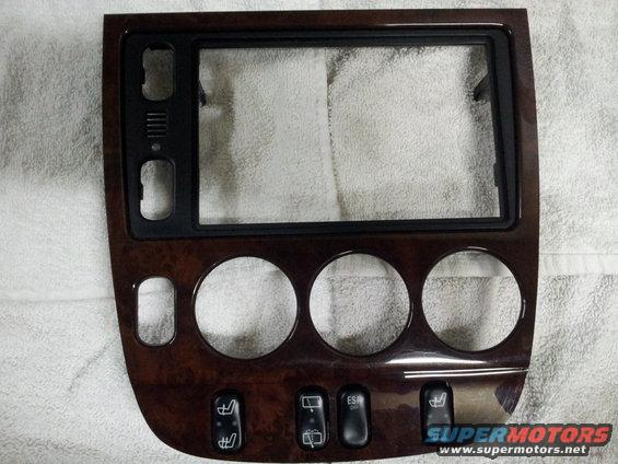 Wood-grain trim piece with openings for radio and climate controls, plus buttons for heated seats and ESP