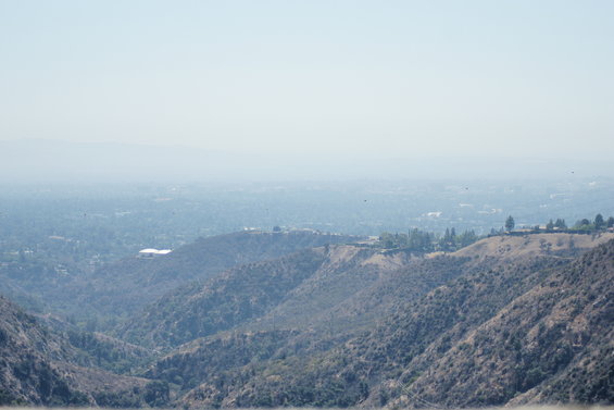View of hills and a distant city under a hazy sky