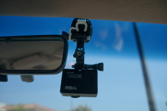 GoPro camera attached to windshield mount near rearview mirror