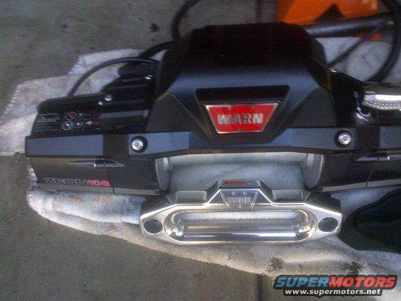 Black Warn Zeon 10s winch with red Warn logo and chrome roller fairlead, resting on a white cloth