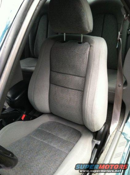 Gray fabric car seats and seatbelt, with a black armrest visible