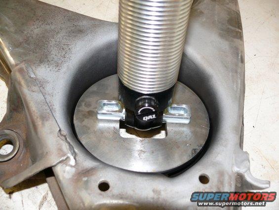 Shock absorber assembly with QA1 branding, attached to a metal suspension component